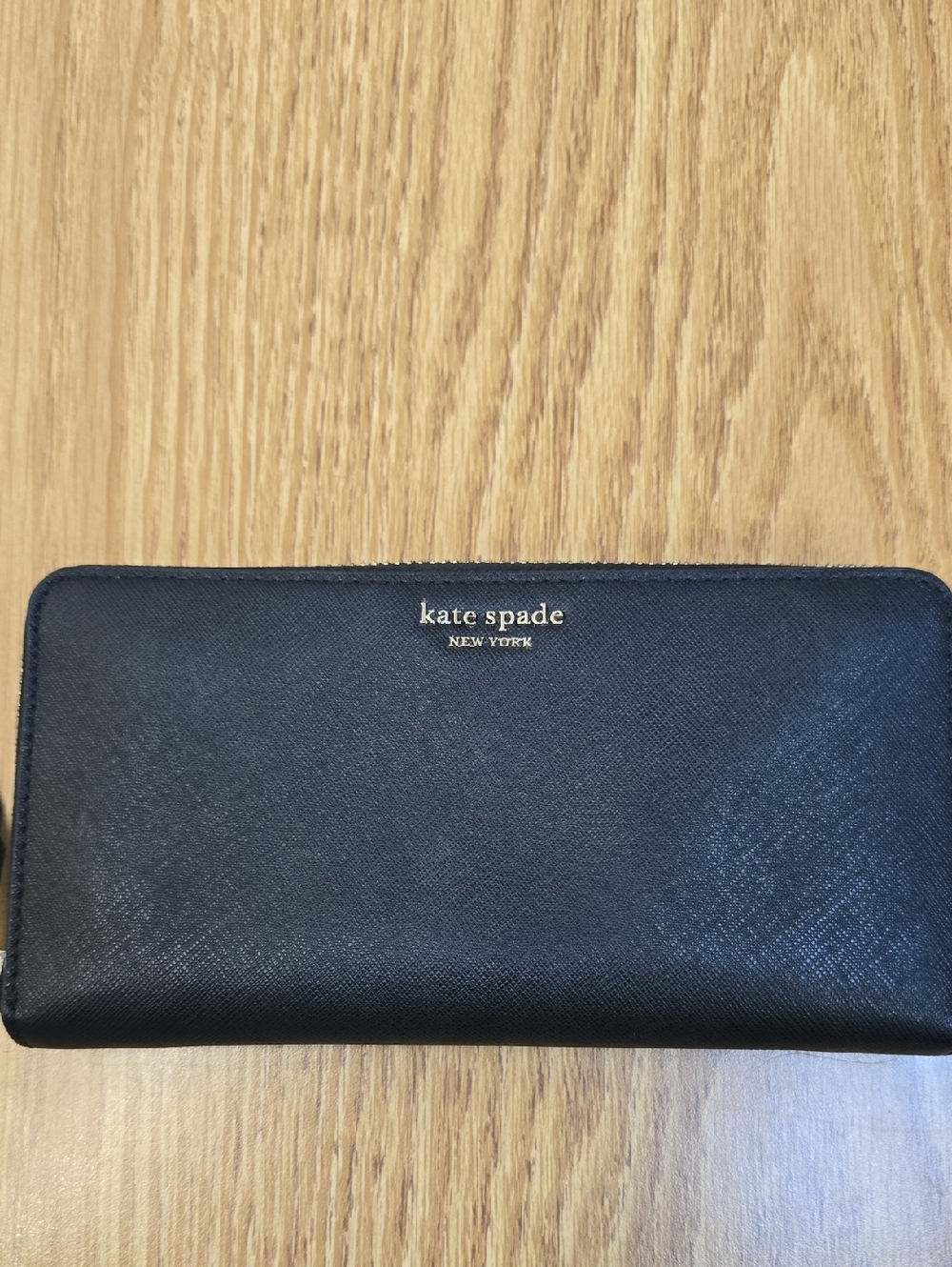 kate spade black zip-around leather wallet with gold logo.